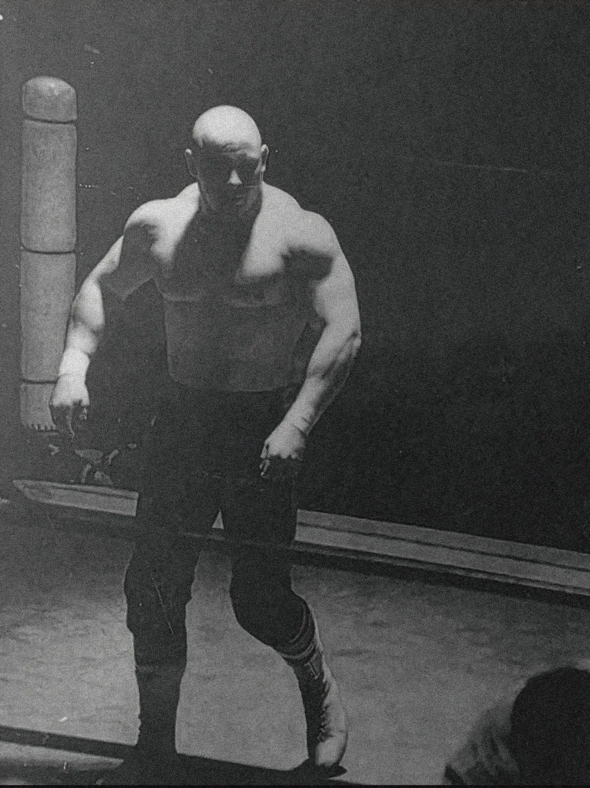 Dynamite feature film key art: a wrestler stands alone in a dark gym